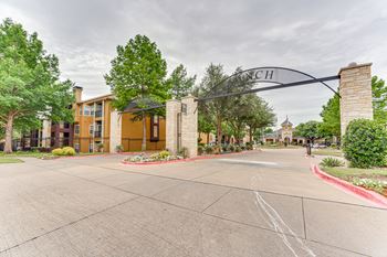 Property entrance archway with stone columns and landscaping